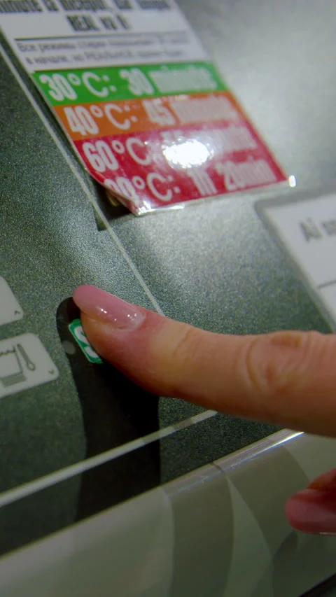 Hand pressing button on washing machine control panel to select high temperature Vídeo Stock 330282821