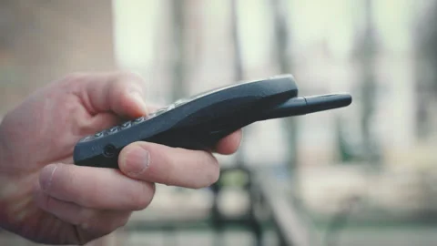 Hand pressing buttons on old mobile phone, close-up shot, blurred background Stock Footage 304980276