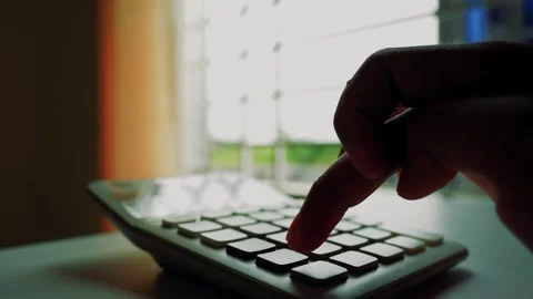 Hand Pressing Calculator Buttons by Window, Close-up of a hand pressing but.. Stock Footage 317737011