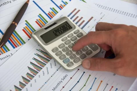 Hand pressing calculator with graph analysis background. Business analysis .. Stock Photos