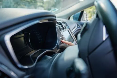 Hand pressing car engine start button inside modern vehicle Stock Photos