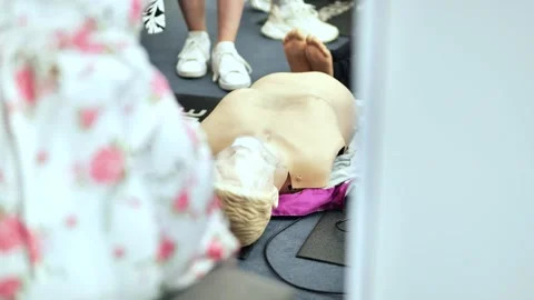 Hand pressing chest of a CPR dummy during a first aid course at a medical forum Stock Footage 323754356
