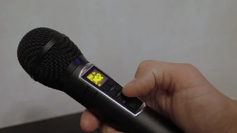 Hand pressing control button on wireless microphone Stock Footage 342863543