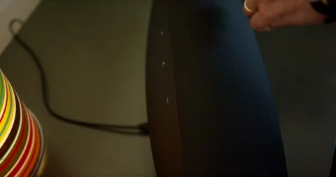 Hand Pressing Controls on Wireless Speaker, Warm Living Room, Close Up Shot Stock Footage 341326318