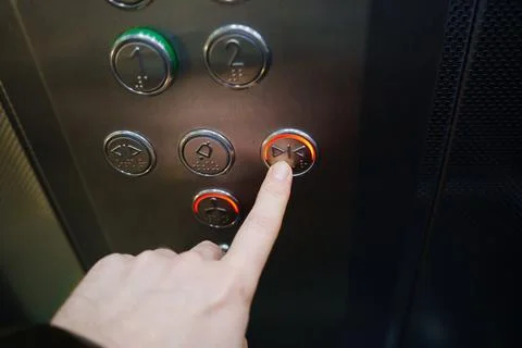 Hand pressing elevator button to go down in a building Foto stock