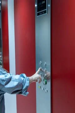 Hand pressing elevator button in modern building with sleek design, showcas.. 스톡 사진
