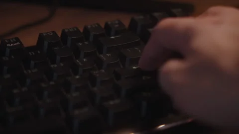 Hand pressing "Enter" key on keyboard from top view in warm light Stock Footage 327354728