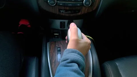 Hand pressing gearshift lever in car interior close-up, operating transmission Stock Footage 333649904