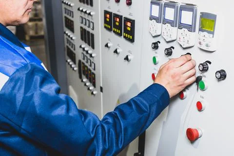 Hand pressing on green button of the machine in the factory Stock Photos