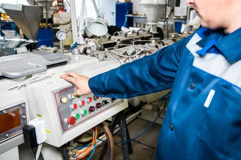 Hand pressing on green button of the machine in the factory Stock Photos