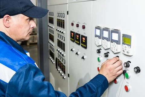 Hand pressing on green button of the machine in the factory Stock Photos