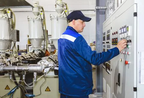Hand pressing on green button of the machine in the factory Stock Photos