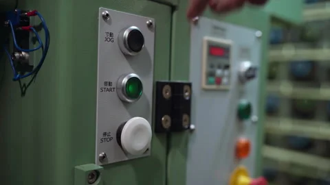 Hand pressing green start button on industrial control panel inside textile work Stock Footage 321889912
