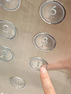 Hand Pressing Illuminated Elevator Button on Modern Control Panel Fotos Stock