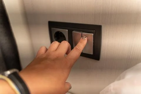 Hand Pressing Light Switch on Modern Wall Electrical Panel Stock Photos