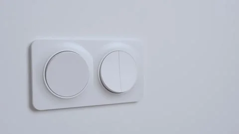 Hand pressing light switch to turn on lighting Stock Footage 323679977