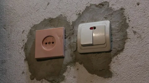 Hand Pressing Light Switch on Unfinished Wall During Home Renovation Stock Footage 335637362