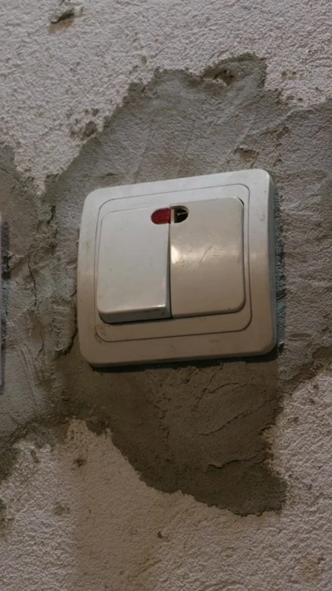 Hand Pressing Light Switch on Unfinished Plaster Wall During Renovation Stock Footage 335640145