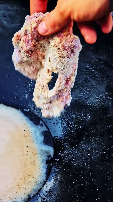 Hand pressing meat into breadcrumb coating beside bowl of beaten egg wash Stock Footage 336717558