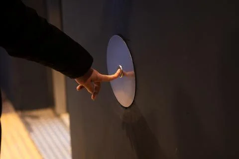 Hand pressing modern call button for elevator access Stock Photos