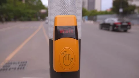 Hand pressing pedestrian crossing wait button at intersection Video stock 337974806