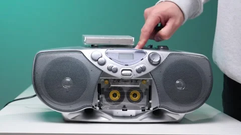 Hand pressing play button on an old fashioned silver cassette player, enjoying Stock Footage 345530502