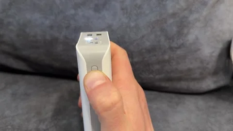 Hand pressing power button on portable device close up, switching small 動画素材 337121285