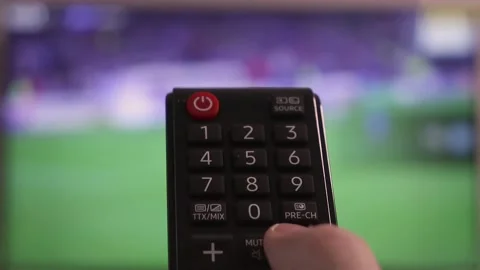 Hand pressing remote control buttons and changing TV channels Stock Footage 222014217