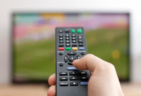 Hand pressing remote control Stock Photos