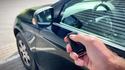 Hand Pressing Remote Key Fob Button to Lock Black Car Door Security Stock Footage 346499296