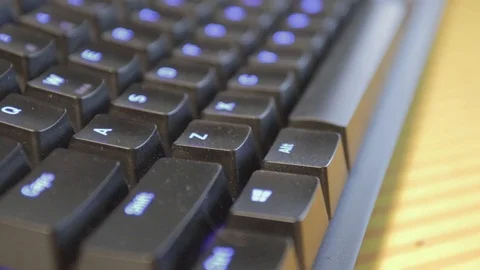 Hand pressing a single key on a slightly dusty, black keyboard with blue Stock Footage 114105489