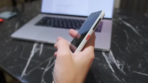 Hand pressing smartphone power button to turn screen off, close-up of locking Stock Footage 333649760
