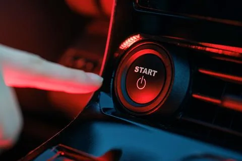 Hand pressing start button on car panel, action activation concept Stock Photos