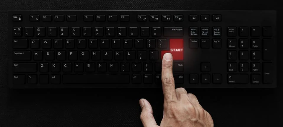 Hand pressing start button on computer keyboard Foto stock
