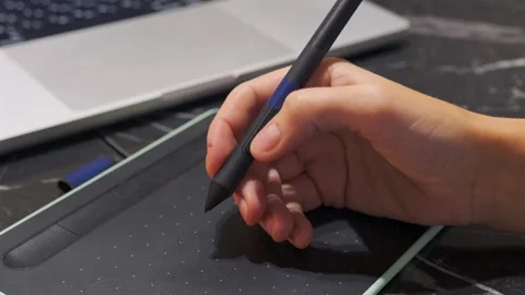 Hand pressing stylus pen button on graphic drawing tablet, close-up of digital Stock Footage 333649836