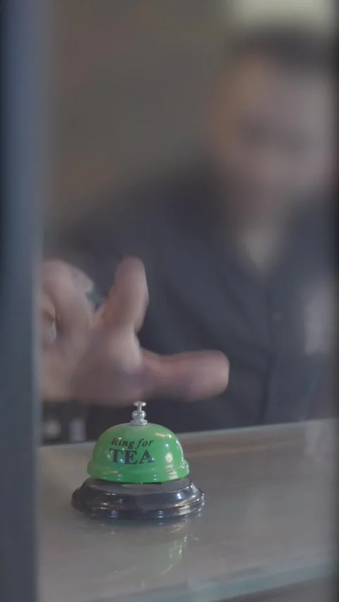 Hand pressing tea bell, cafe service bell ring, counter with tea bell Stock Footage 305795260