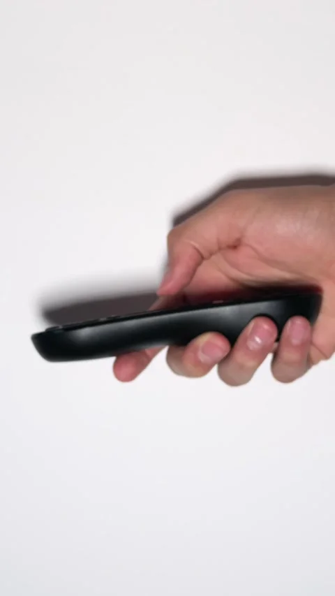 Hand pressing TV remote control against white background Stock Footage 312902858