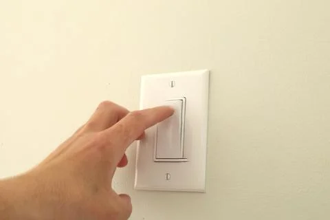 Hand pressing wall light switch Stock Photos