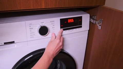 Hand pressing washing machine control panel buttons to select program, close-up 스톡 동영상 333649753