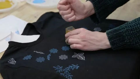 Hand-printed pattern on fabric. Print a picture on a black T-shirt. Modern Stock Footage 170356853