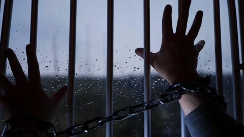Hand of prisoner in chains against prison bars Stock Footage 172263331