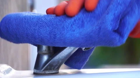 Hand in protective glove using wet wipe to disinfect the water tap Stock Footage 147868892