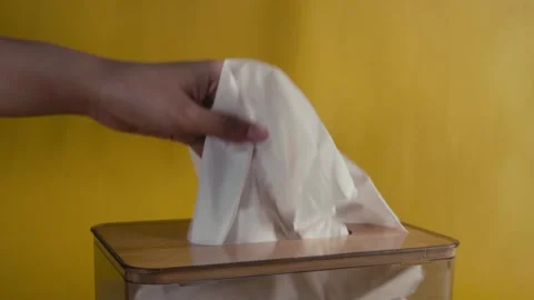 Hand pull out tissues form tissue box with isolated yellow background Stock Footage 269125254