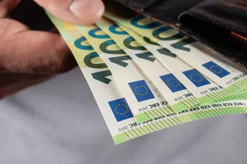 Hand pulling 100 Euro banknote from wallet Stock-Fotos