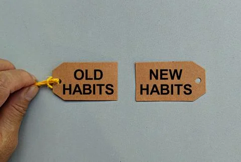 Hand pulling a card written old habits and another new habits Stock Photos