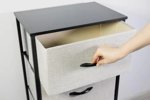 A hand pulling close a modern fabric dresser drawer. Stock Photos