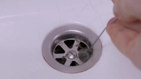 Hand Pulling Hair Blockage Out Of Bathroom Sink Drain Close Up Stock Footage 330299267