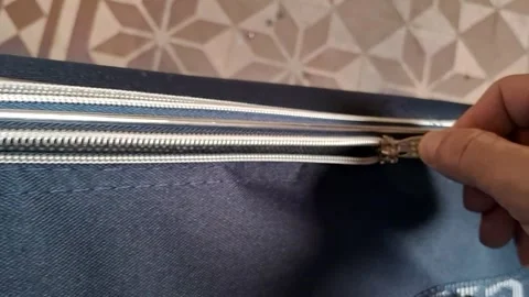Hand pulling metal zipper on blue fabric luggage motion video footage Stockbeeldmateriaal 339248221