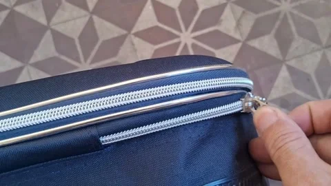 Hand pulling metallic zipper on blue travel suitcase motion video footage Stock Footage 339247317