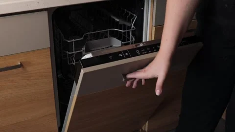 Hand pulling open the door of a built-in stainless steel dishwasher, reveal.. Stock Footage 320737767